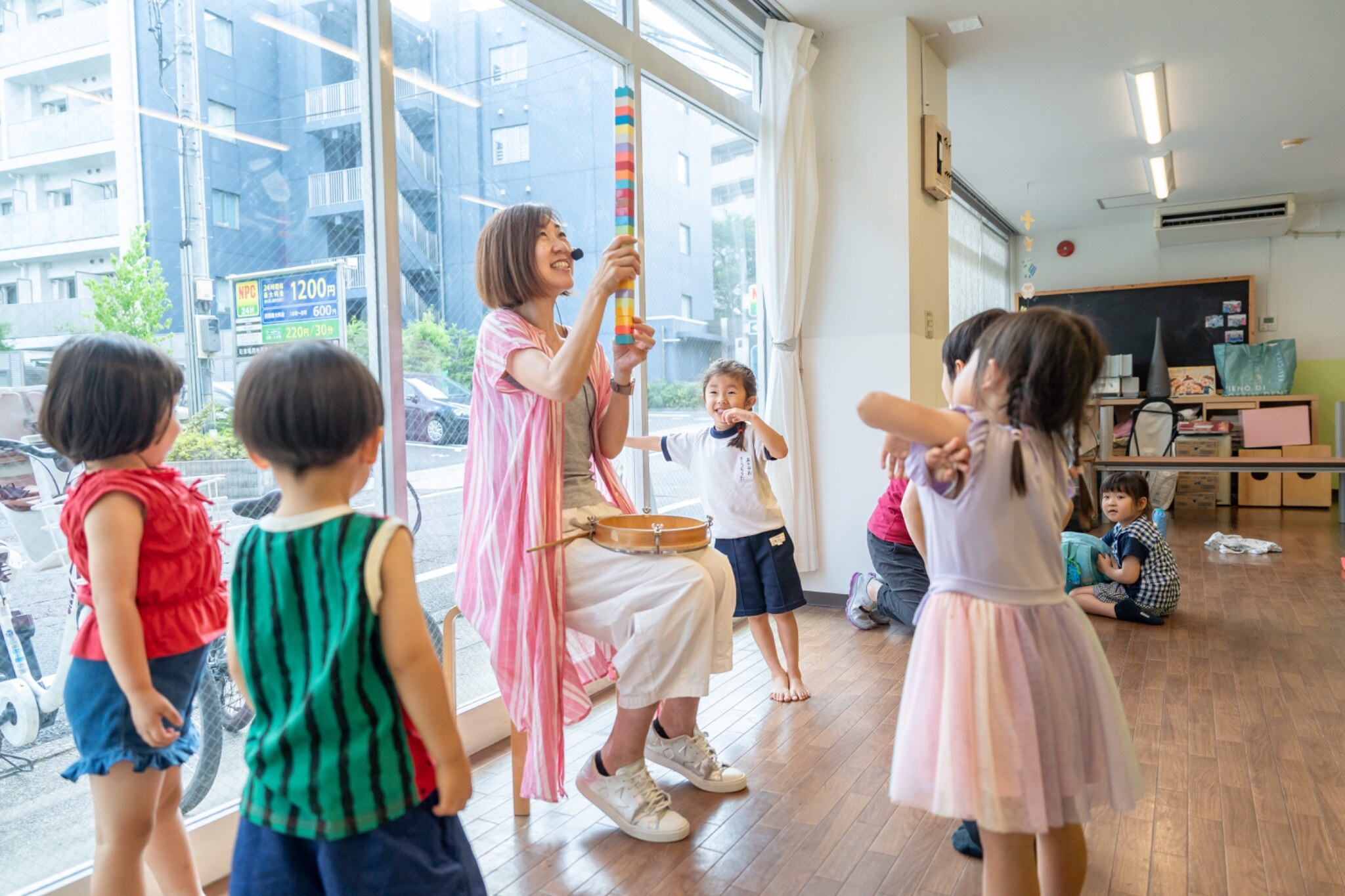 明るい教室で先生と一緒に音や表現を楽しむ子どもたち